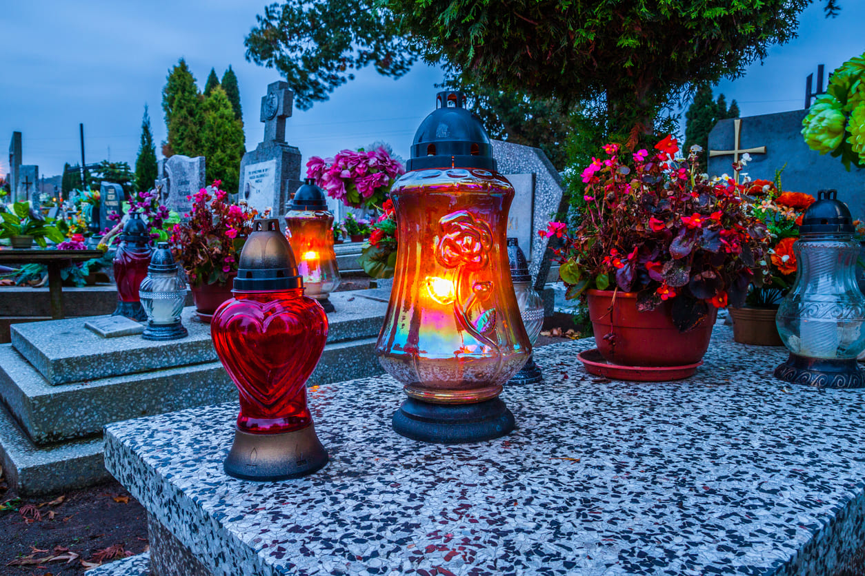 A cemetery in Poland beautifully lit with candles and adorned with flowers on All Saints' Day, as families honor their departed loved ones.