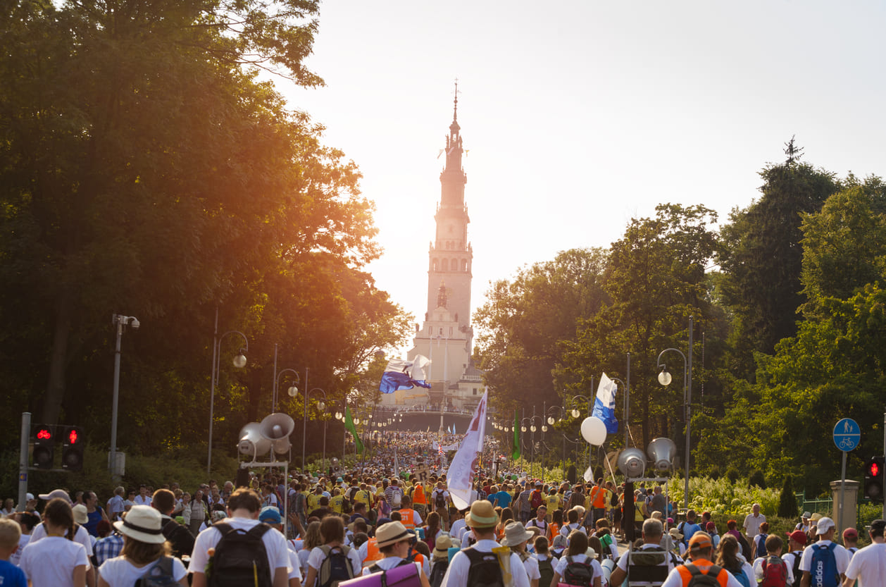 A large crowd of pilgrims walks toward Jasna Góra Monastery in Częstochowa, gathering for Assumption Day celebrations in Poland.