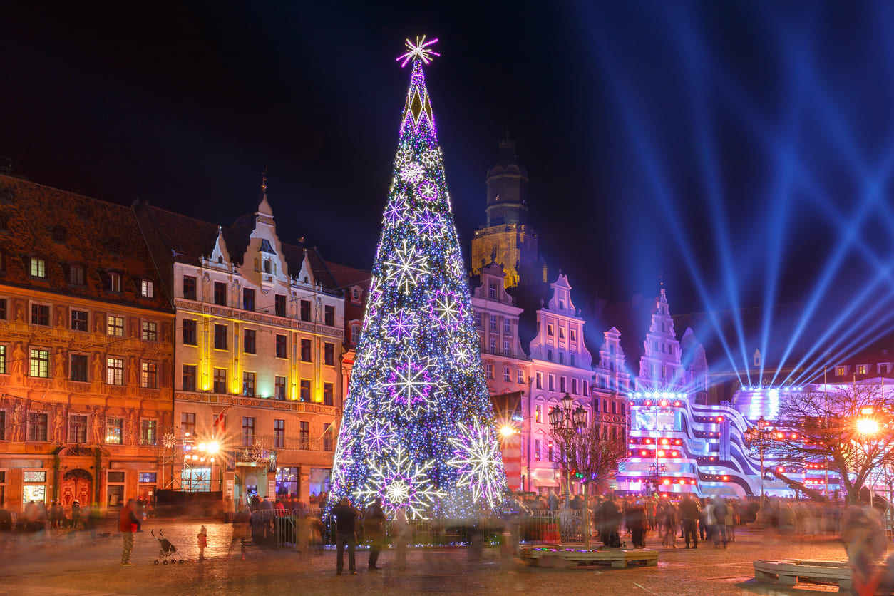 A beautifully illuminated Christmas tree, surrounded by festive lights and holiday celebrations.