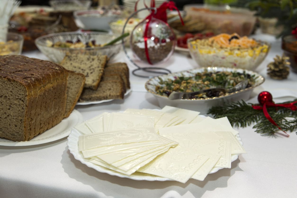 A traditional Polish Christmas Eve table set with Christmas wafers, bread, and a variety of festive dishes, symbolizing togetherness and holiday traditions.