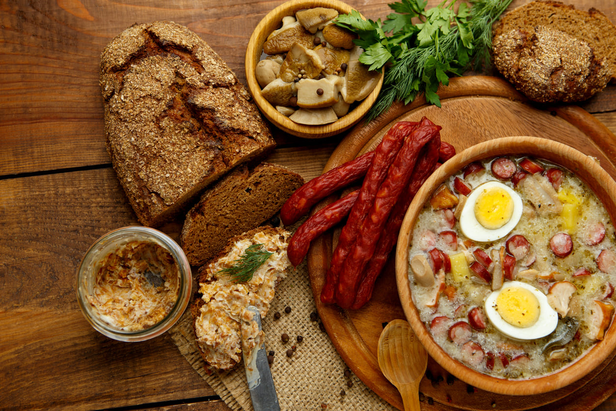 A traditional Polish Easter spread with bread, sausage, eggs, and a rich soup, symbolizing the festive Easter meal.