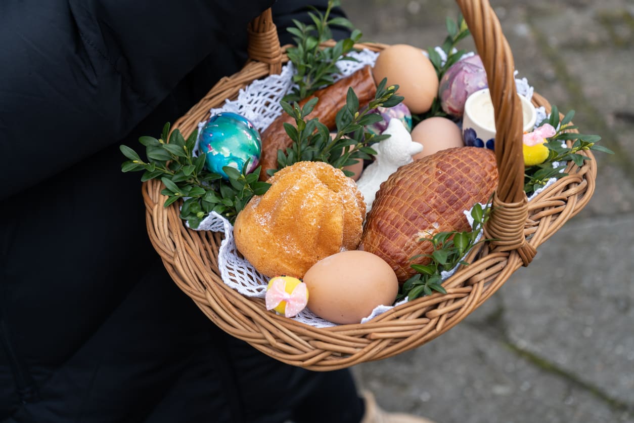 A wicker basket filled with decorated eggs, bread, sausage, and other traditional Easter foods, prepared for the blessing on Holy Saturday in Poland.