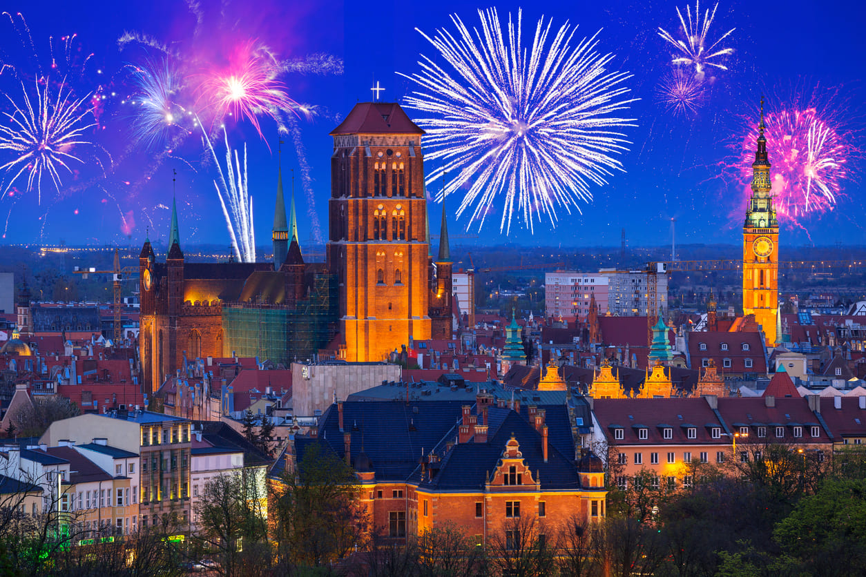 A stunning view of Gdańsk, Poland, illuminated by vibrant New Year's Day fireworks over its historic architecture.