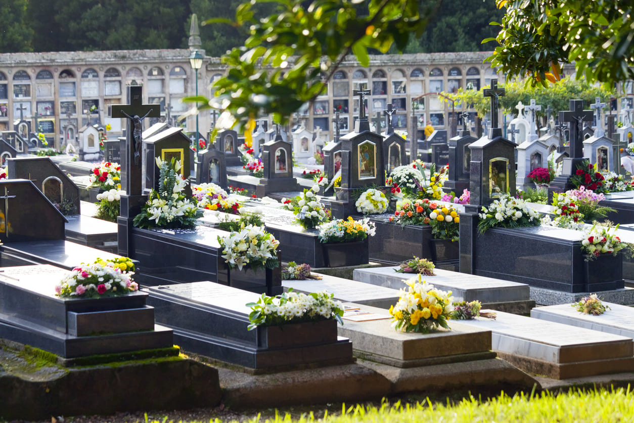 A peaceful cemetery filled with beautifully decorated graves, adorned with fresh flowers, symbolizing remembrance and tribute on All Saints' Day in Spain.