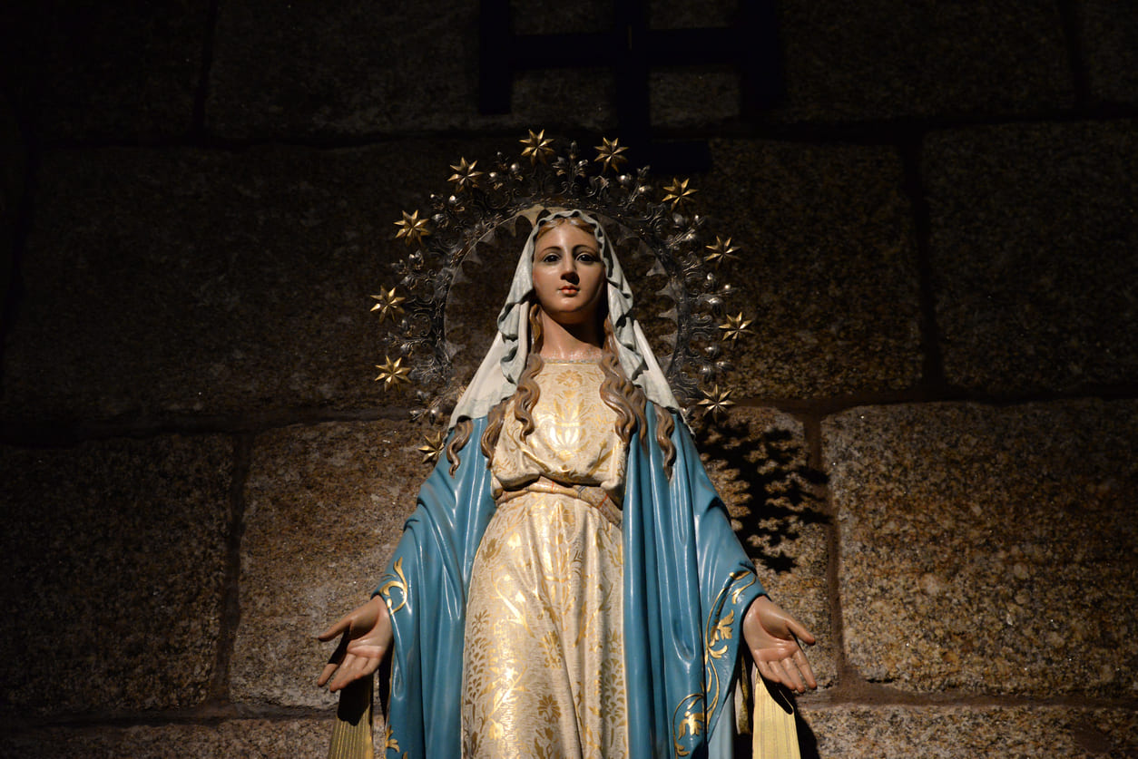 A serene statue of the Virgin Mary, adorned in elegant robes and a radiant halo, symbolizing faith and devotion on Assumption Day.