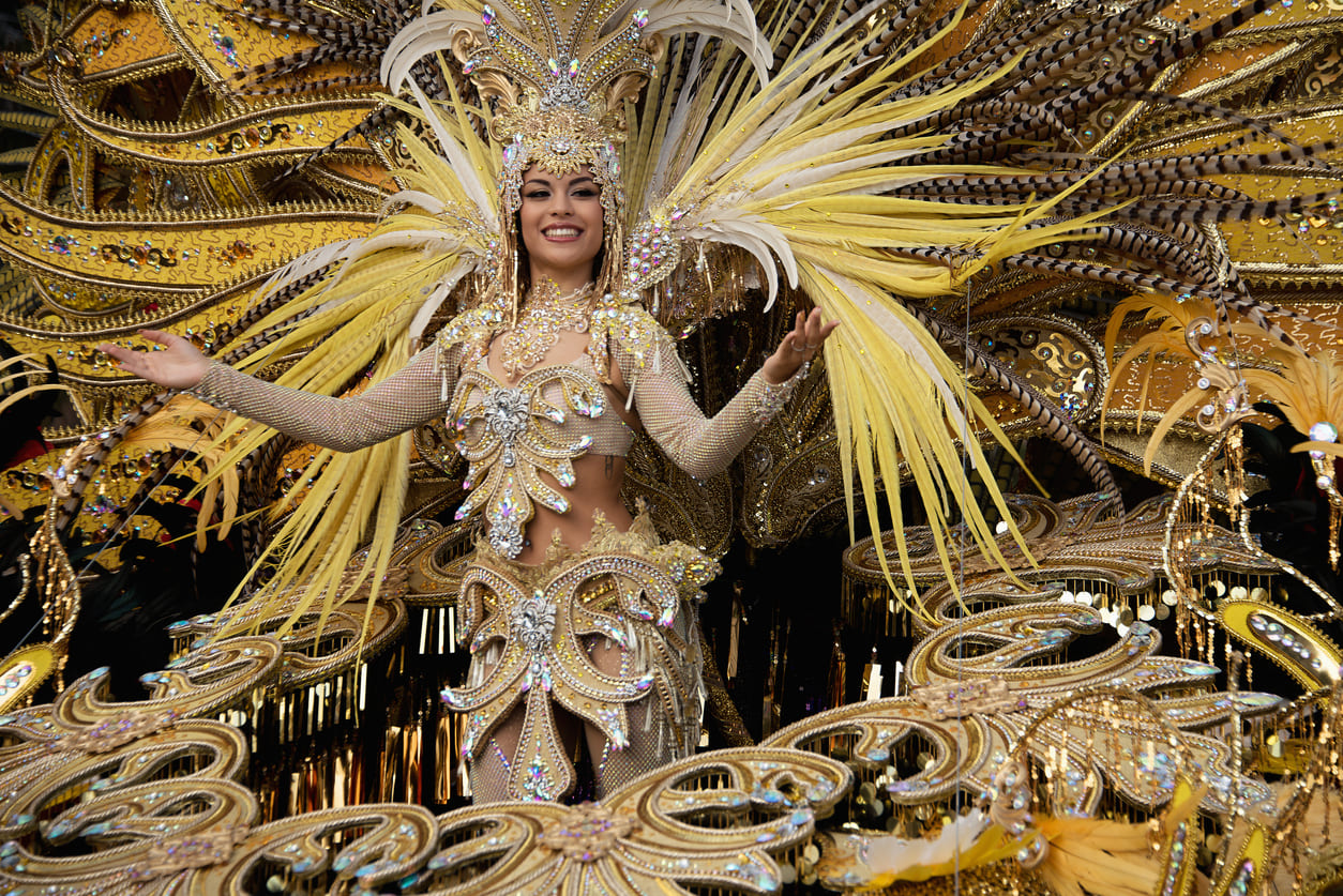 The Queen of the Carnival shines in a breathtaking golden costume adorned with feathers and jewels, leading the grand final parade of Carnival Tuesday with grace and splendor.