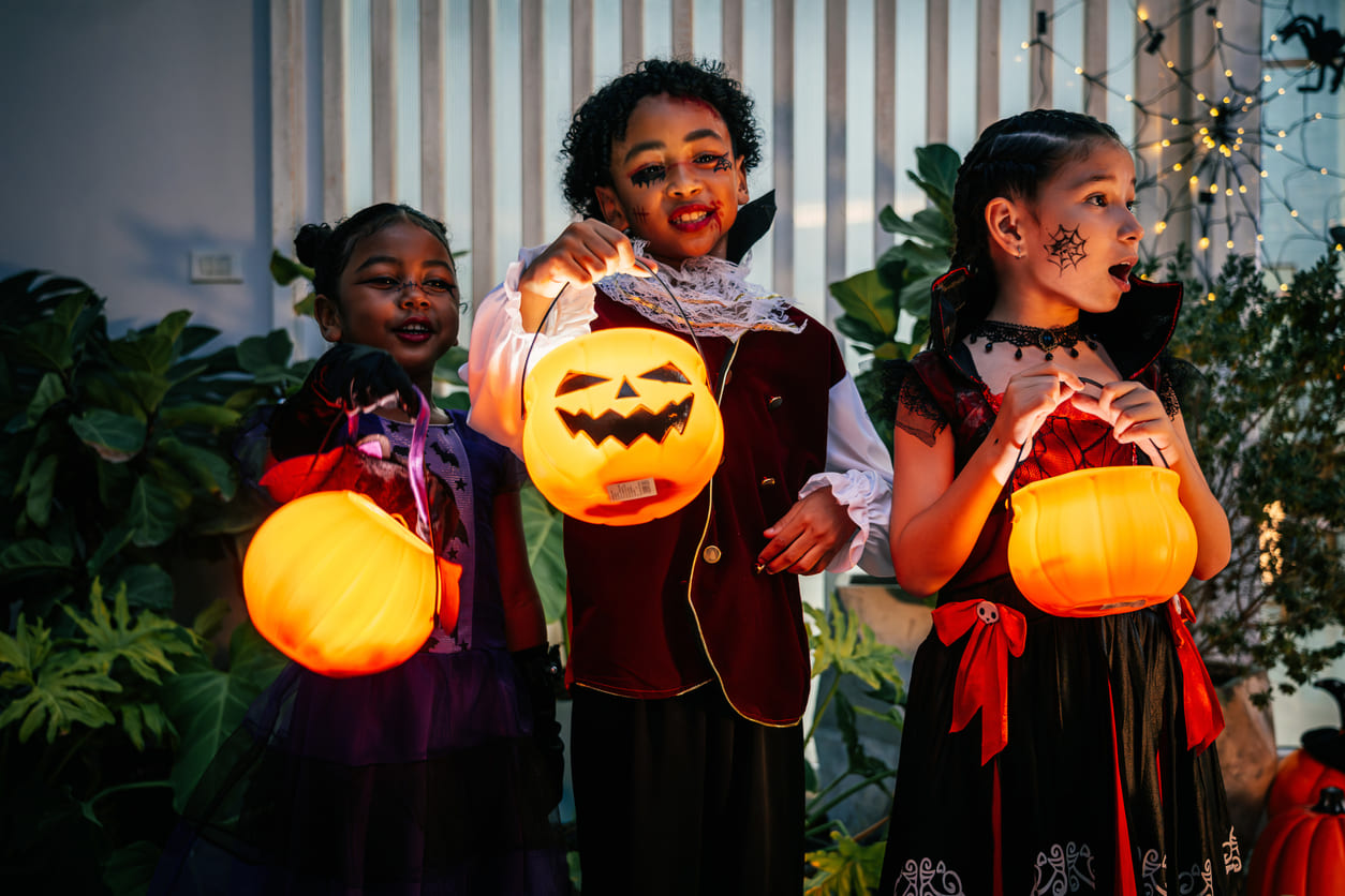 Children wearing Halloween costumes and holding pumpkin lanterns, capturing the festive mood of Halloween celebrations in Thailand.