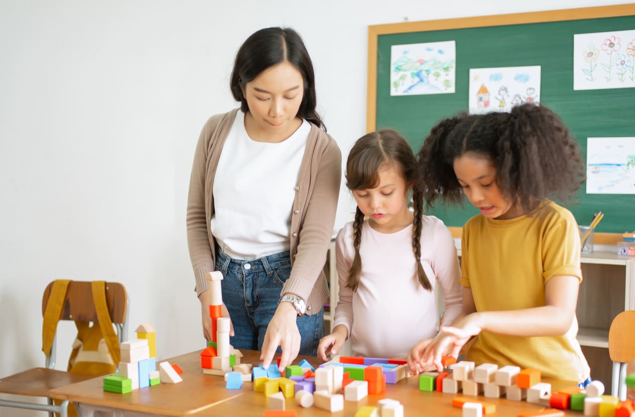 A teacher helping young students with educational activities, symbolizing the guidance and support celebrated on Teachers' Day.