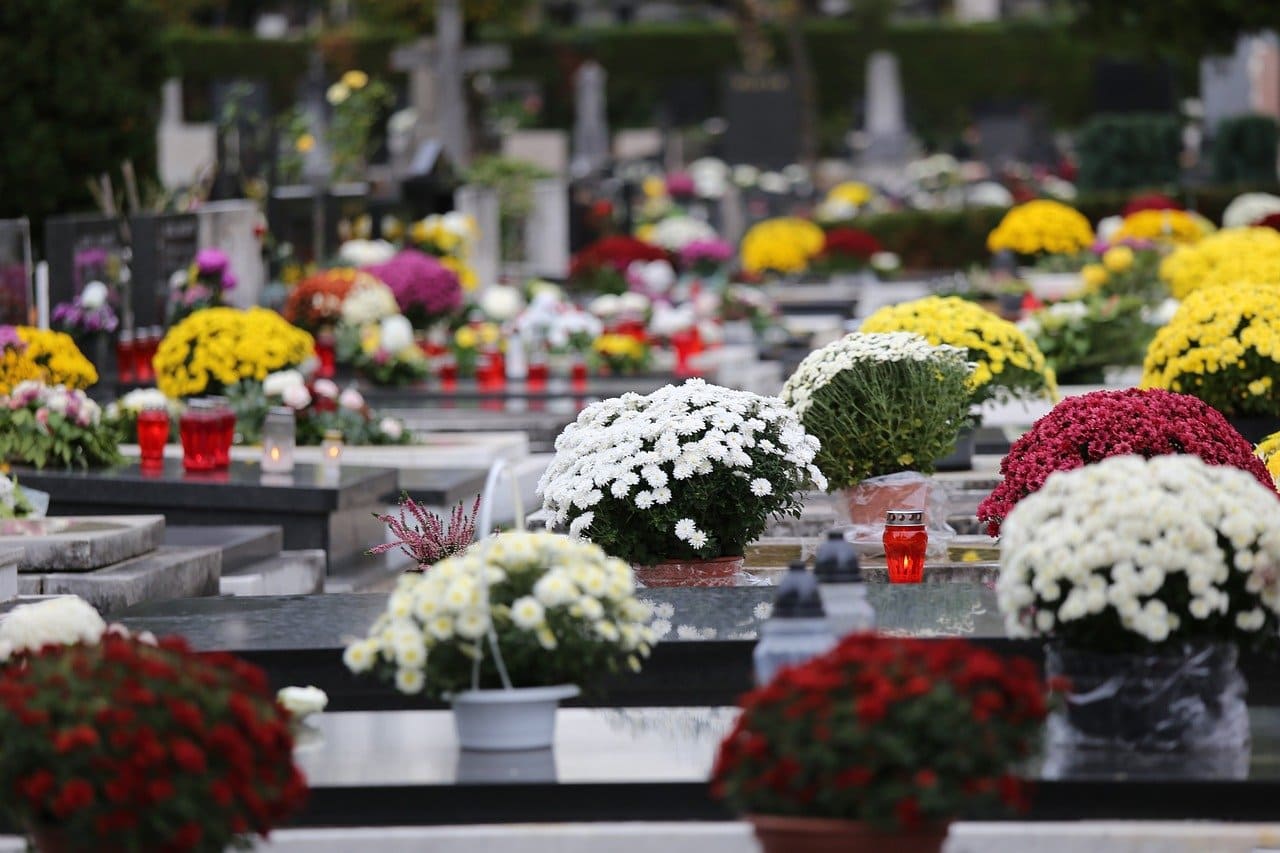 Graves adorned with flowers and candles to honor and remember the departed on All Souls' Day.