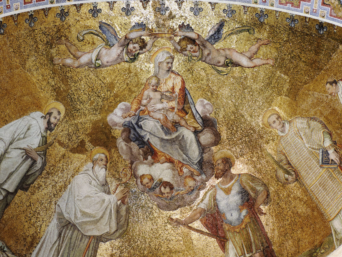 A stunning mosaic depicts the Assumption of the Virgin Mary, showing her crowned and surrounded by saints and angels as she ascends to heaven.