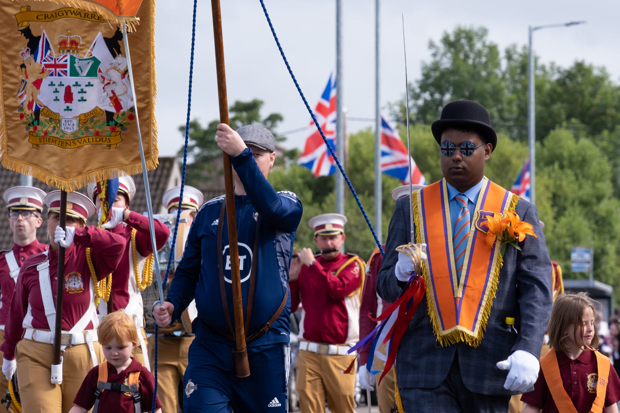 Orange Order Twelfth parade, celebrating the Battle of the Boyne with banners, music, and traditional sashes.