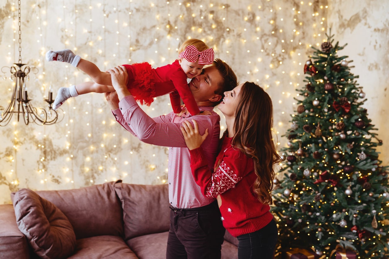 A joyful family enjoys festive moments together by the Christmas tree, capturing the spirit of Boxing Day with love and celebration.