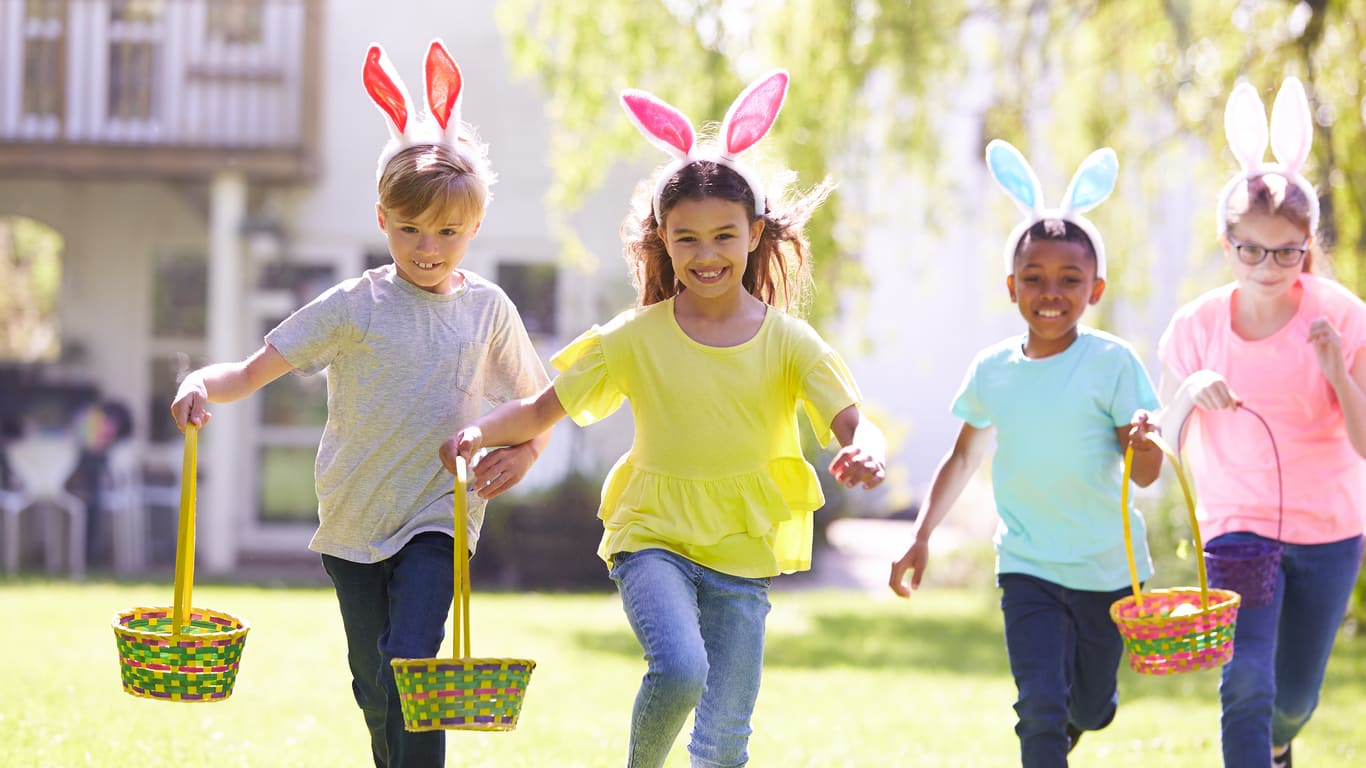 Children wearing bunny ears enjoy an Easter egg hunt, embracing the festive springtime spirit.