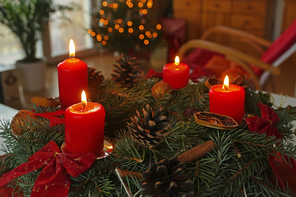 A festive Advent wreath with red candles and pine decorations, symbolizing hope and the countdown to Christmas.