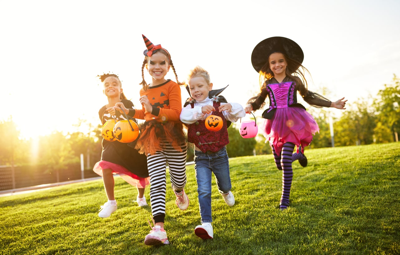 Excited kids in spooky costumes go trick-or-treating during Halloween celebrations.