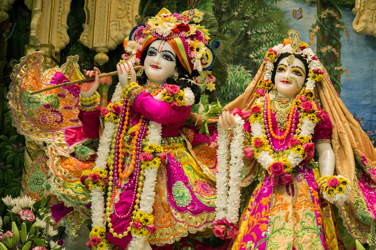 Colorful idols of Lord Krishna and Radha adorned with flowers and festive attire, capturing the spirit of Janmashtami.