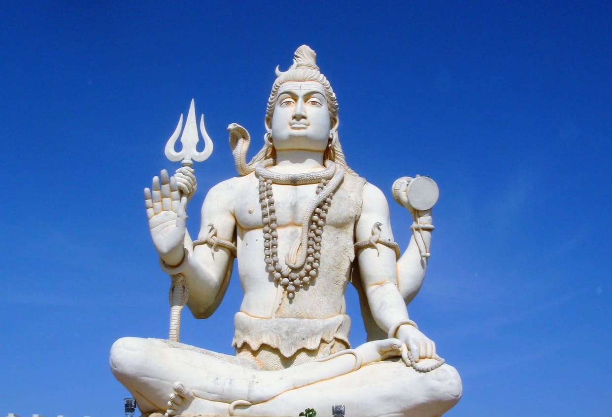 A grand statue of Lord Shiva in a meditative posture, symbolizing divine power and serenity.