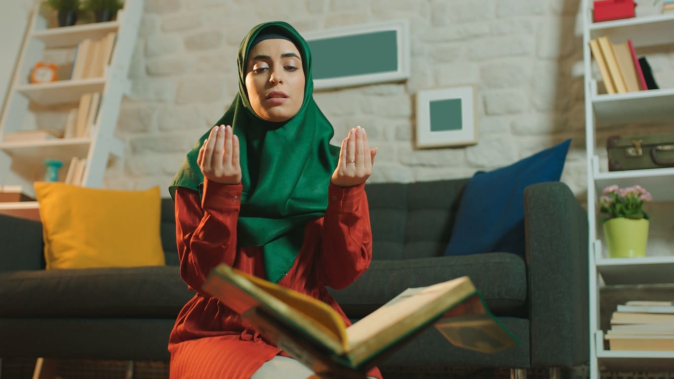 A woman prays deeply, reflecting on the life and teachings of the Prophet Muhammad during Milad Un Nabi.