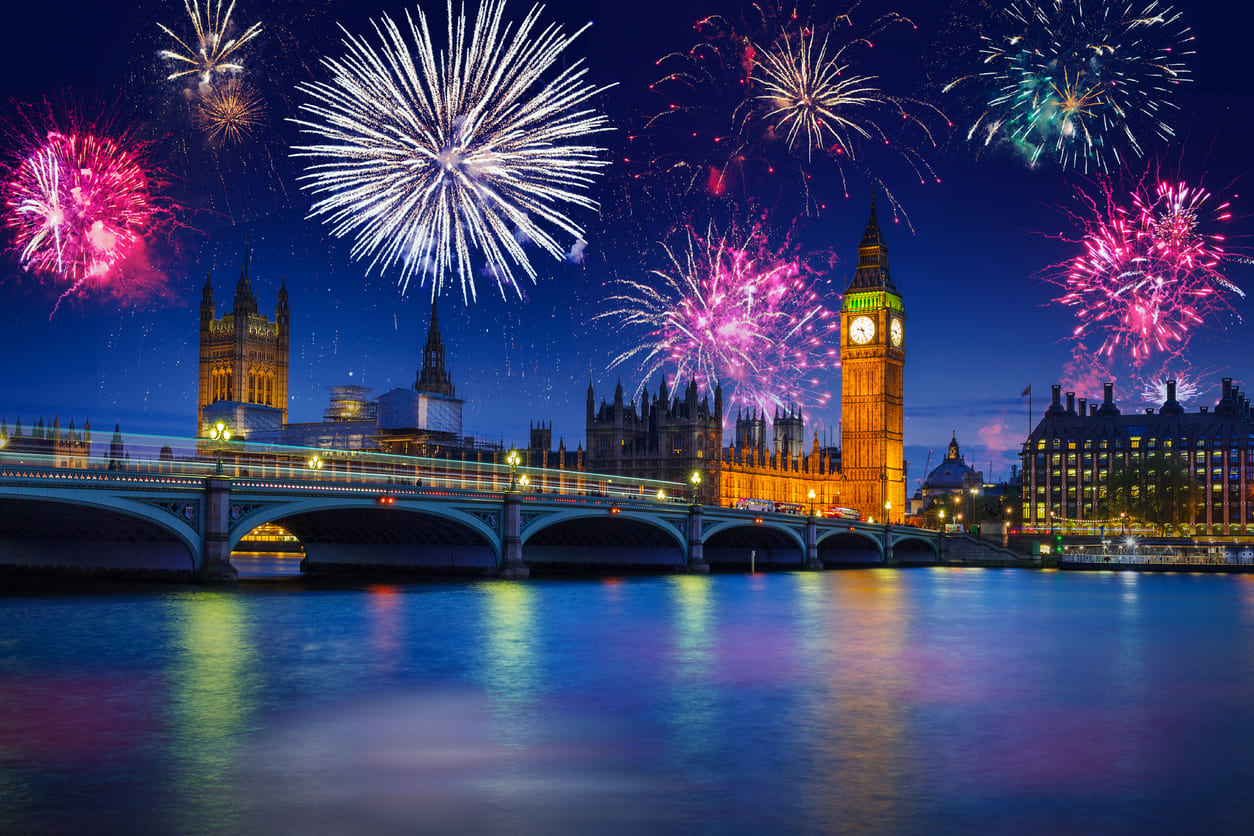 Fireworks illuminate the night sky over Big Ben and the River Thames, marking New Year's Eve celebrations in London.