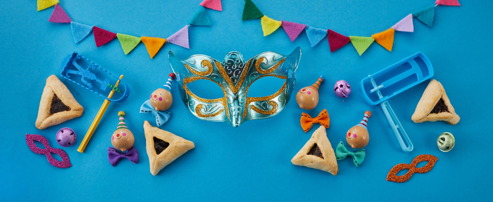 Colorful elements of Purim, including masks, noisemakers, festive decorations, and hamantaschen pastries, capturing the joyful spirit of the holiday.