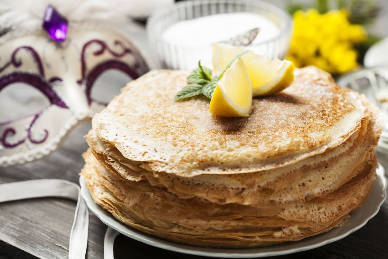 Pancakes garnished with lemon wedges and a hint of sugar, ready to celebrate the delicious tradition of Pancake Day.