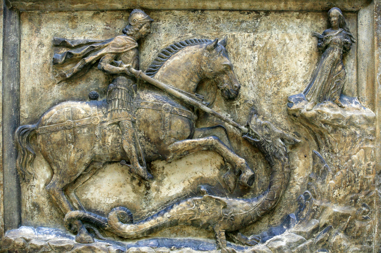 An ancient stone relief depicting St. George heroically slaying the dragon, symbolizing the triumph of good over evil.