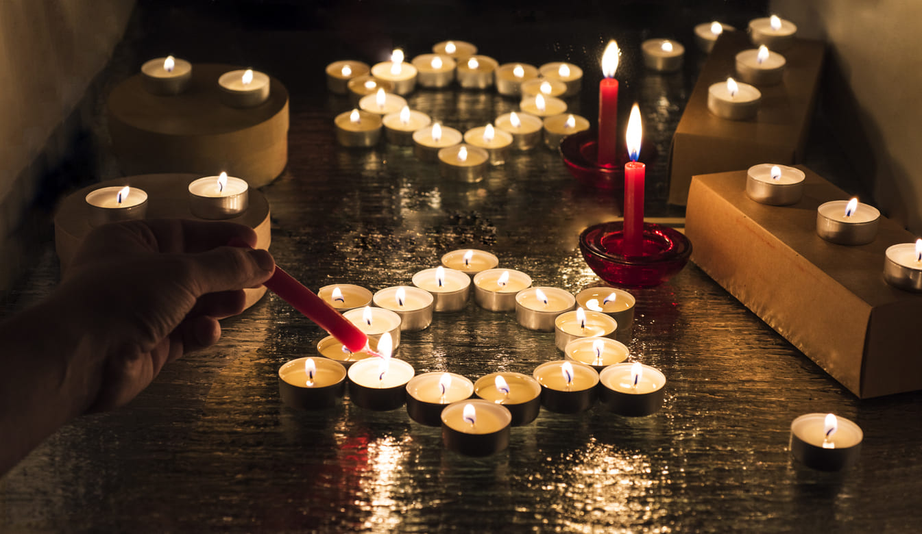 Candles arranged in solemn patterns are lit in remembrance, honoring Holocaust victims on Yom HaShoah.