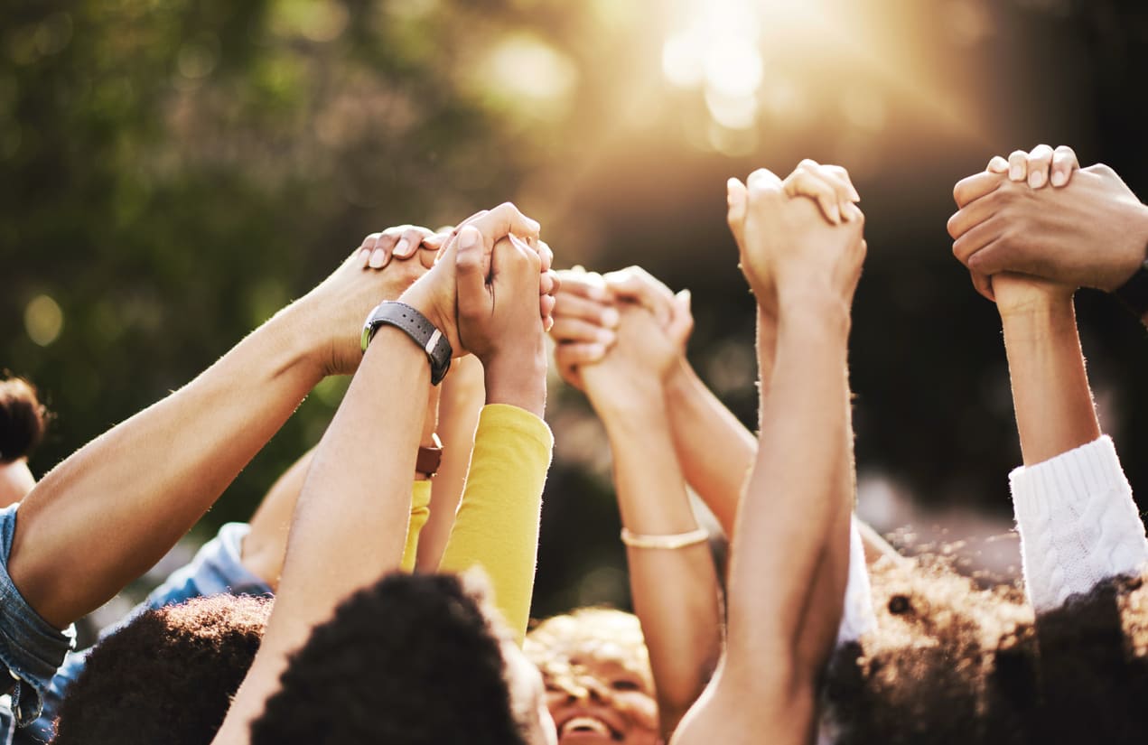 A group of diverse hands raised together in unity, symbolizing harmony and mutual support.