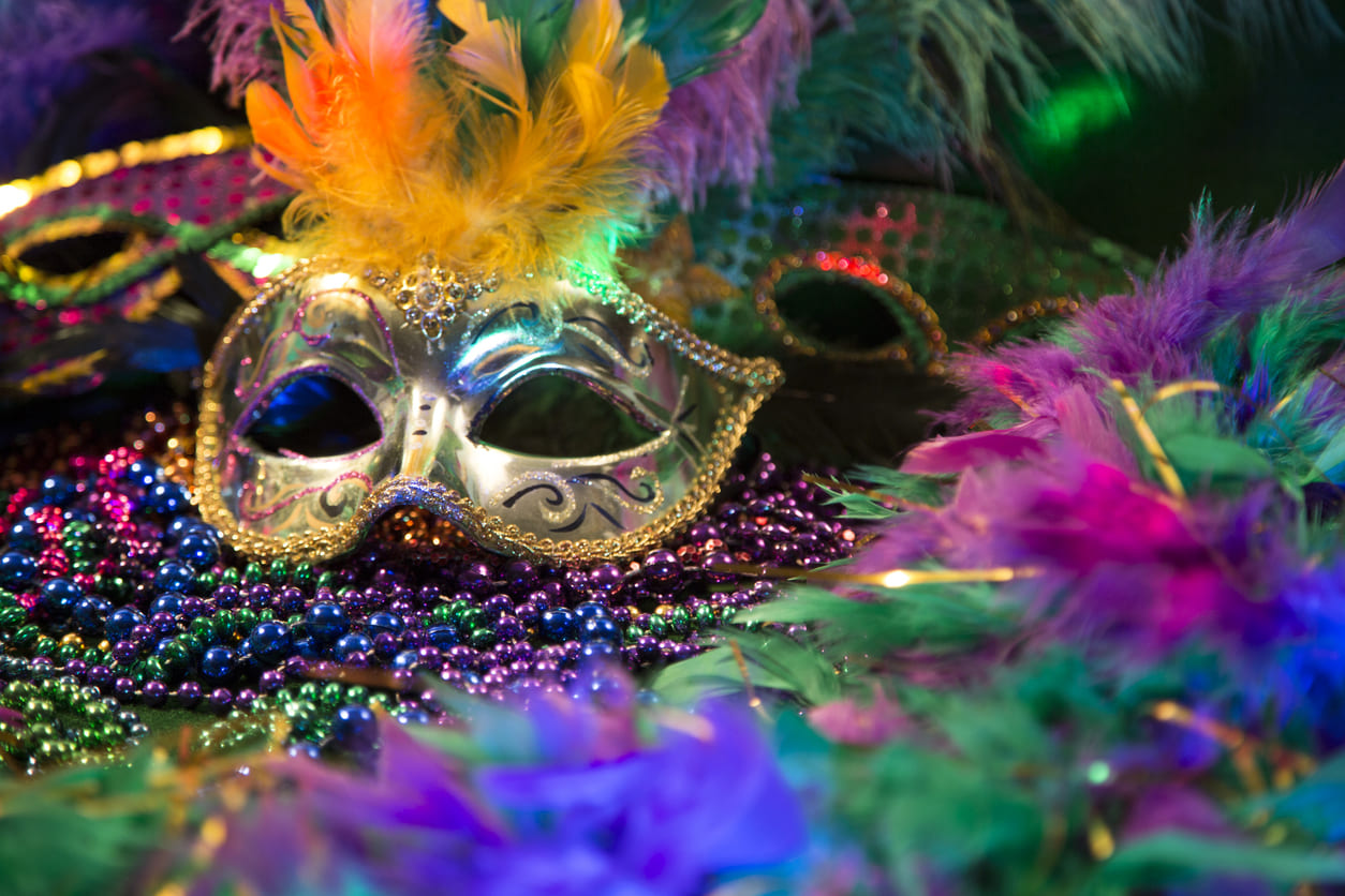 A decorative Mardi Gras mask adorned with vibrant beads and feathers, capturing the essence of the celebration.