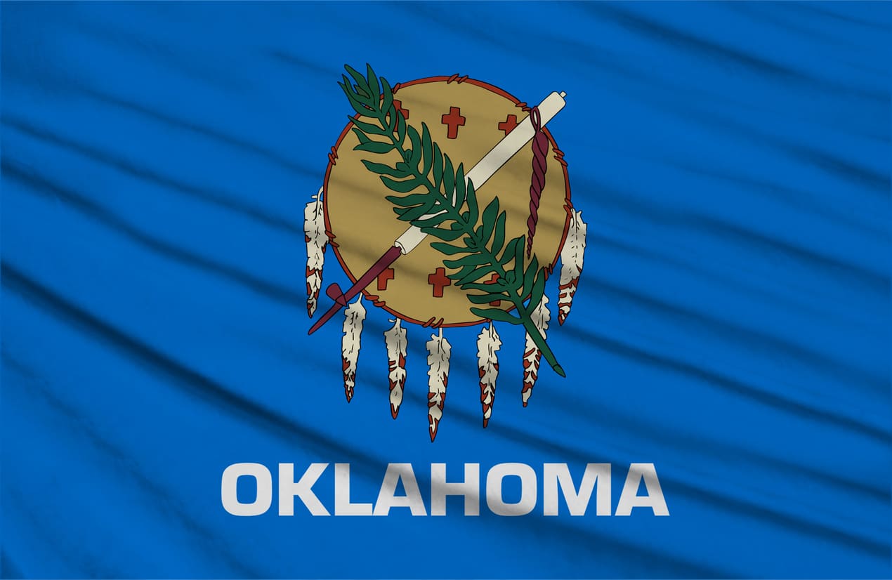 The Oklahoma state flag features a Native American shield with symbols of peace on a blue background.