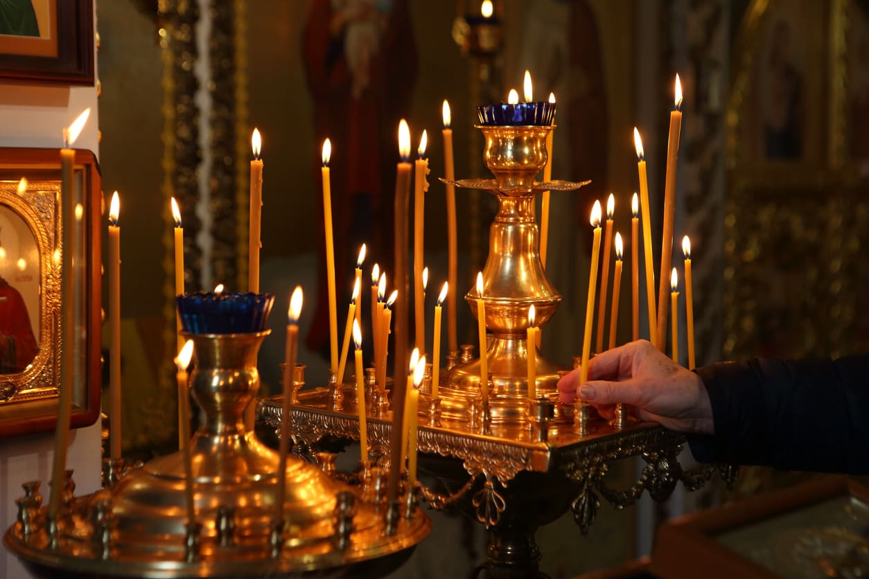 Lit candles in an Orthodox church, symbolizing prayer, reflection, and reverence during a solemn occasion like Good Friday.