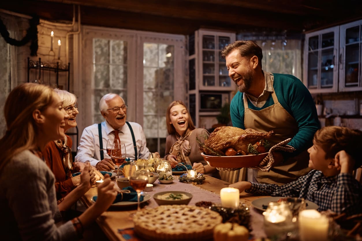 A joyful family gathers around the table, sharing a traditional Thanksgiving feast.