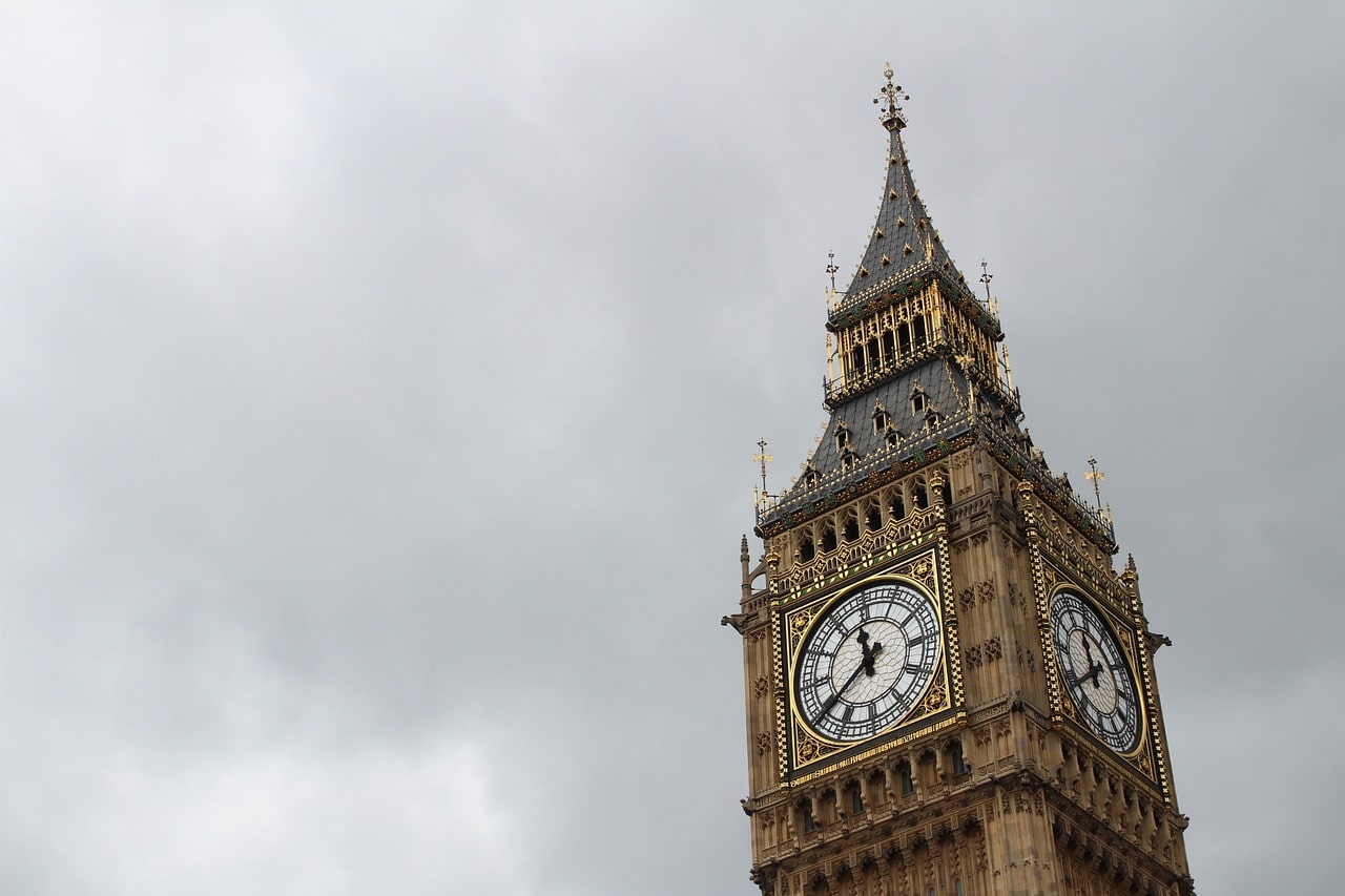 Big Ben's tower and clock face stand prominently against the cloudy sky.