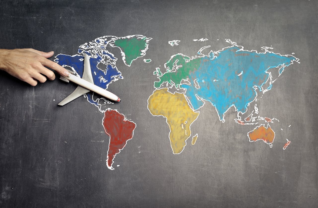 A person holding a toy airplane over a world map, symbolizing travel and exploration.